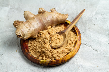Ginger root and powder in wooden container