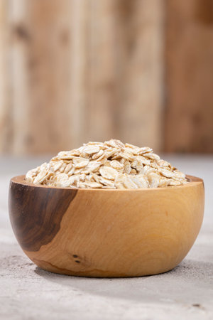 Oat flakes in wooden container, close-up