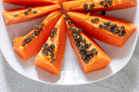 Chunks of papaya with its healthy seeds served on a white plate, Carica papayaの写真素材