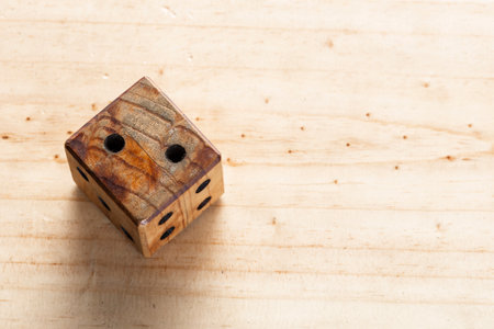 wooden dice on a pine surface, the dice shows the number 2の写真素材