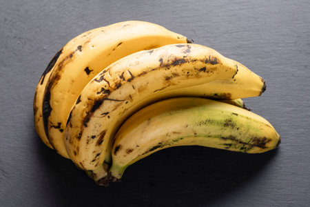 You can see in the image a bunch of bananas on a gray board, top view