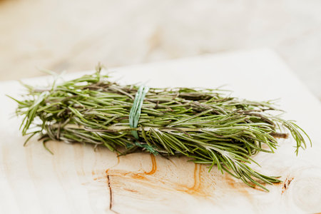 In the image you can see a bunch of rosemary leaves on a wooden surfaceの写真素材
