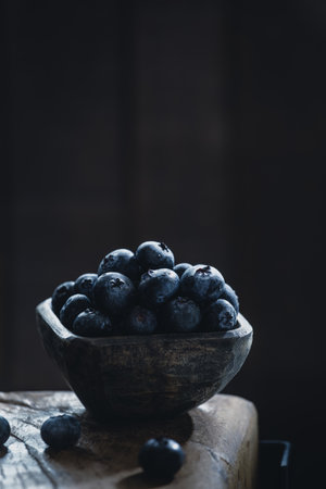 Pile of blueberry in wooden container, on a dark background, close-upの写真素材