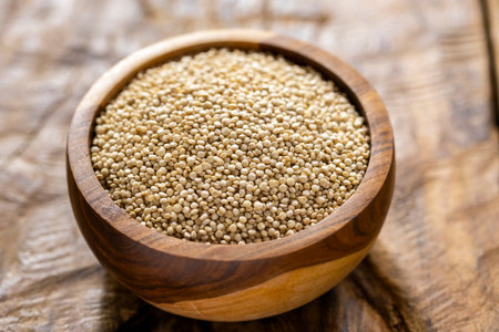 A pile of quinoa grains is seen in the image, in a wooden containerの写真素材