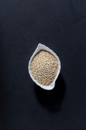 A pile of quinoa grains is seen in the image, in a ceramic containerの写真素材