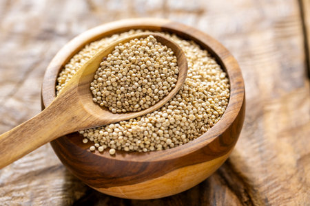 A pile of quinoa grains is seen in the image, in a wooden containerの写真素材