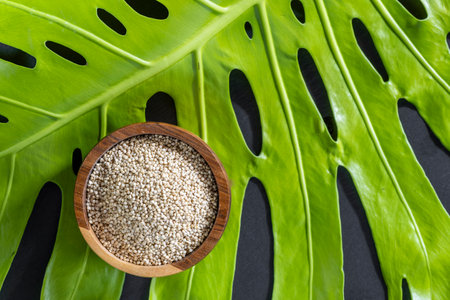 A pile of quinoa grains is seen in the image, in a wooden containerの写真素材