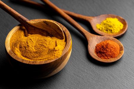 Colorful Spices on Wooden Spoons â Curry, Turmeric, and Paprika on Dark Slate Backgroundの写真素材