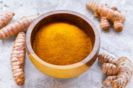 Fresh and Ground Turmeric on Rustic Background â€“ Natural Health and Culinary Ingredient