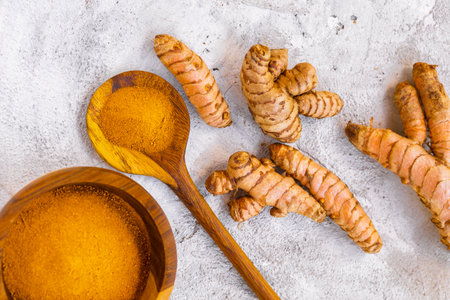 Fresh and Ground Turmeric on Rustic Background â€“ Natural Health and Culinary Ingredient