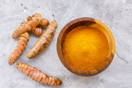Fresh and Ground Turmeric on Rustic Background â€“ Natural Health and Culinary Ingredient
