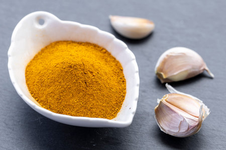 Fresh and ground turmeric root on a slate backgroundの写真素材