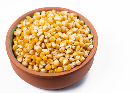 Bowl with popcorn kernels on a white backgroundの写真素材