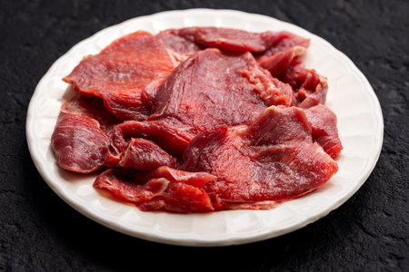 Raw Beef Meat Slices on White Plate, Top Viewの写真素材