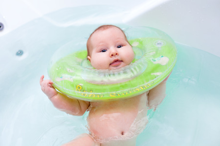 The baby swims in the bathtub in the circleの写真素材