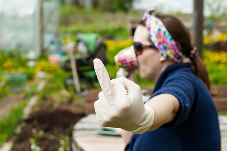 Woman showing middle finger in a rubber gloveの写真素材