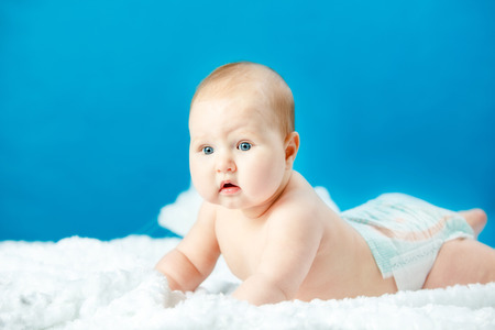 baby in diapers lying on a cloud in the skyの写真素材