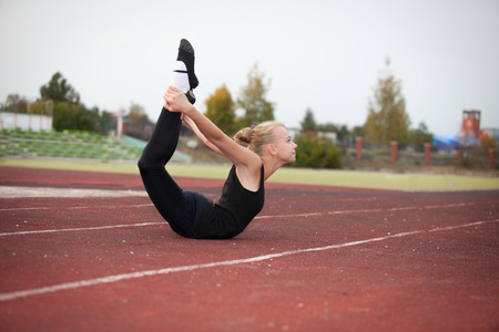 Sports teenage girl in the stadium performs gymnastic exercisesの写真素材