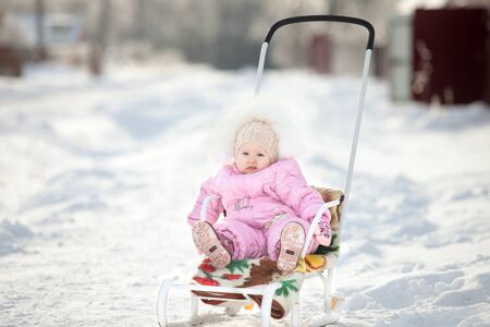 Little girl on sled on winter walk