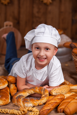 baby cook dressed up lies Baker a lot of bread rollsの写真素材