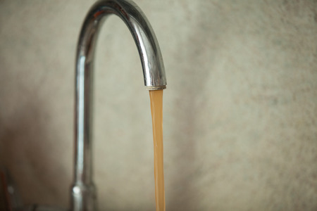 dirty, rusty water flows from the tapの写真素材