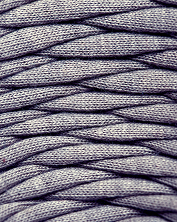 Skein of gray knitted yarn close-up. macro photography background texture pattern weave fiber...
