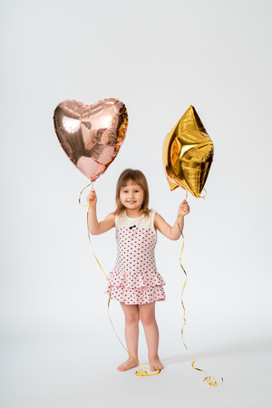 baby with heart shaped balloons and stars on white backgroundの写真素材