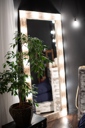 the bedroom is a dark room, with a mirror framed by light bulbsの写真素材