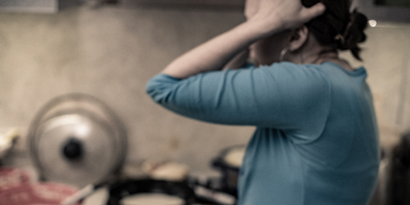 mess in the kitchen a woman holds her head in horror from the chaos. photo blur and dramatic tintedの写真素材