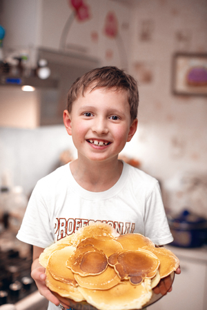 the child is holding a plate of pancakesの写真素材