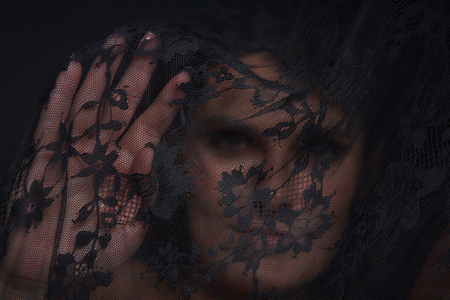 the woman behind the curtain focus on the open palm of the girl's face out of focusの写真素材