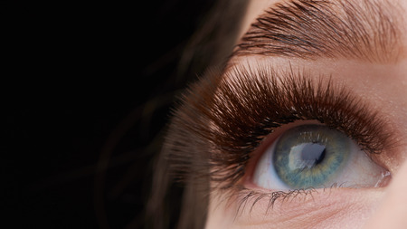 Beautiful macro photography of a woman's eye with extreme make-up of long eyelashes. Perfect long eyelashes. without cosmetics. Close-up fashion eye visage, lamination eyebrow beautifulの写真素材