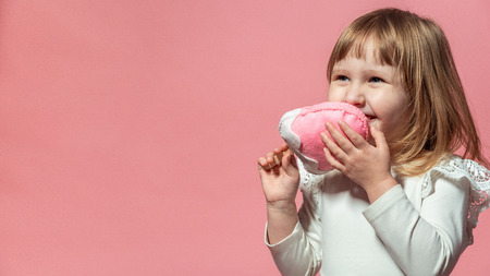 happy kid with ice cream ice cream in hand on a pink coral background. with free text space.の写真素材