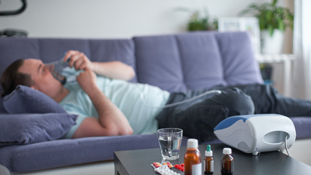 sick man lying on the couch he's blurred. selective focus on medicinesの写真素材