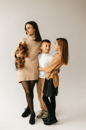 Mom hugs daughter and son on a white background. High quality photoの写真素材
