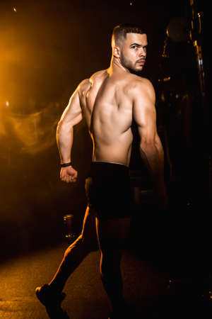 Young man athlete posing in the gym, stimulates to go in for sports. High quality photoの写真素材