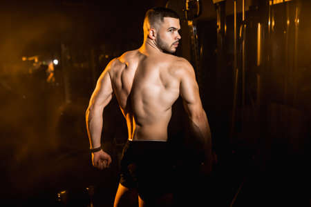 Young man athlete posing in the gym, stimulates to go in for sports. High quality photoの写真素材