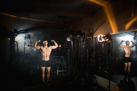 Athlete man in great shape posing in the gym, pumped up muscles, athletic body. High quality photoの写真素材
