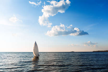 White sailing yacht in the blue ocean. White yacht with sails against the blue sky. High quality photoの写真素材