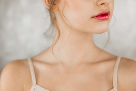 Female portrait half face beautiful painted lips in bright pink color, bare shoulders.の写真素材