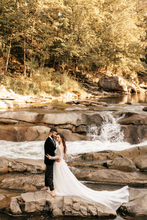 Wedding couple hugs on the background of a stone river. Gorgeous view. High quality photoの写真素材
