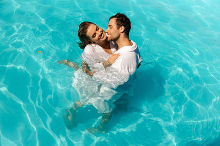 Young, sexy and attractive couple kissing in an embrace in the pool. High quality photoの写真素材