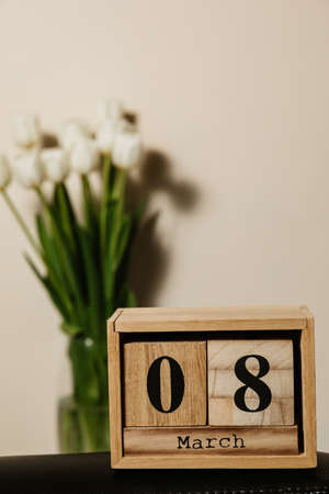 Wooden calendar 8 march, bouquet of white fresh tulips. High quality photo