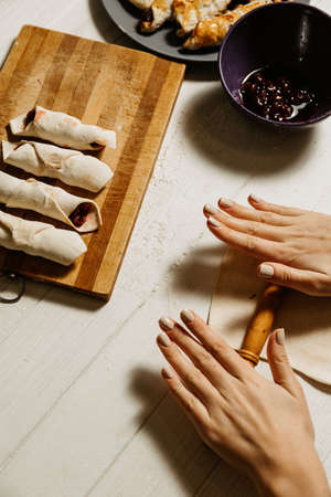 Cooking cherry bagels, baking at home, roll out dough on a white table.の写真素材