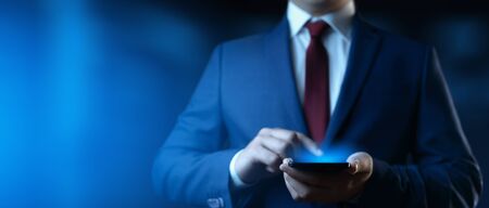 Businessman holding smartphone. Man using phone in office