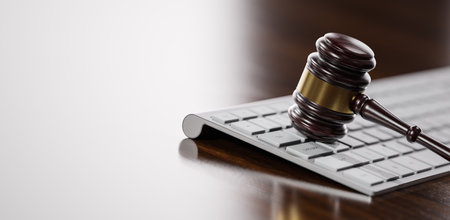 Gavel at the computer keyboard: Legal and law concept. Wooden hammer of justice and order