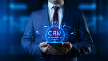 Businessman holding smartphone with CRM Customer Relationship Management icons on screenの写真素材