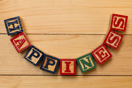 hapiness wood cube words on wooden tableの写真素材