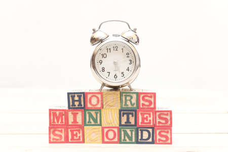 Clock with wood cubes on wooden table words hours,minutes,secondsの写真素材