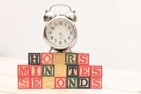 Clock with wood cubes on wooden table words hours,minutes,secondsの写真素材
